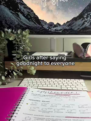 The image shows a workspace with a computer screen displaying a mountain landscape, a keyboard, and an open notebook with handwritten notes. The caption "Girls after saying goodnight to everyone" is overlaid at the bottom.