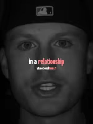 A close-up, grayscale image of a young man's face fills the frame. He wears a baseball cap, and the focus is on his eyes. The text "in a relationship" is overlaid on the image in a pinkish-red font, with the username "@Emotionallines.1" below it.