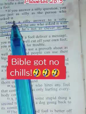 The image shows an open book with text and a pen partially obscuring it. A red rectangular text overlay with the words 'Bible got no chills!' is positioned at the bottom. The pen is blue with shiny appearance. The book's pages are aged, and the focus is on a highlighted line that reads 'Give a silly answer to a silly question'.