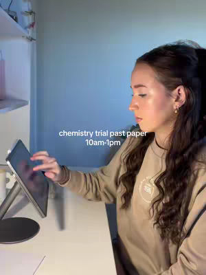 A young woman with long dark hair is seated at a desk with a tablet, touching the screen. Text overlays the image, providing context about the video's content. The background suggests a study environment, and the lighting has a blue tint, creating a mood.