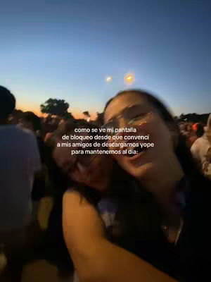 The cover image shows two young women smiling and embracing, appearing to be friends. They are situated in front of a blurry crowd and a gradient sky transitioning from orange to blue, suggesting a sunset or sunrise. Text overlays the image.