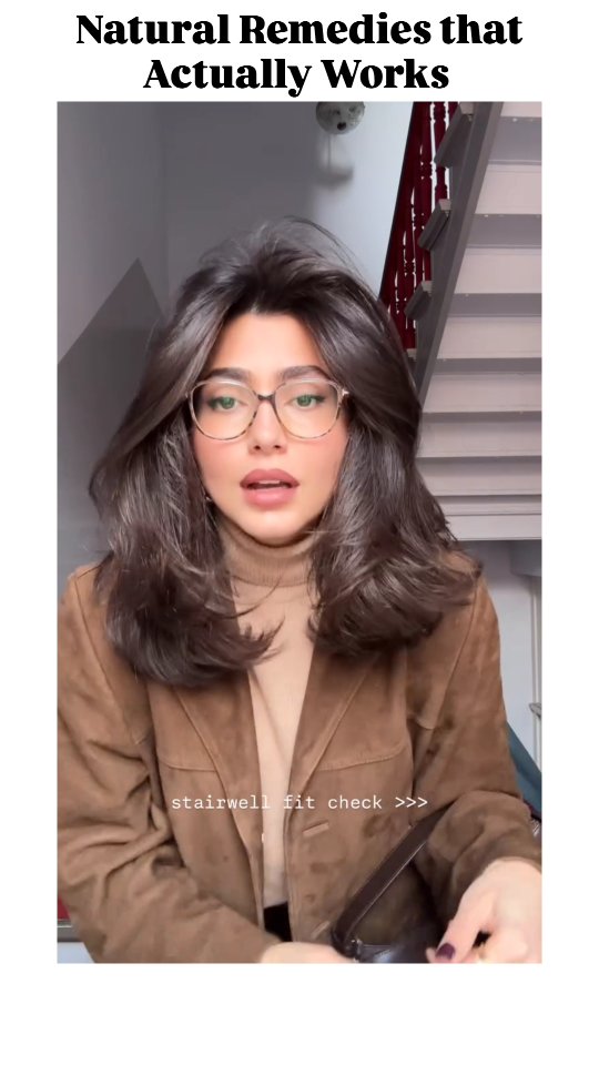 A woman with dark hair and glasses is centered in the frame, with "Natural Remedies that Actually Works" text written at the top. She is wearing a brown blazer and a turtleneck, with a staircase visible in the background.