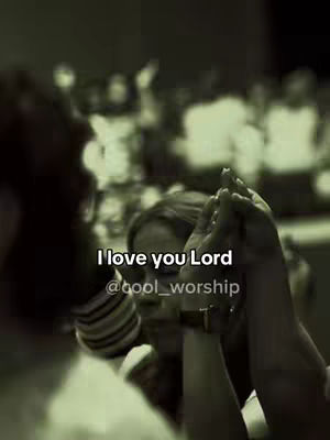 The image shows a close up of two hands clasped together with a woman in the background, and the text overlayed is 'I love you Lord'