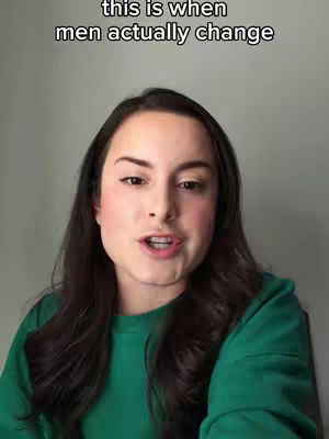 A woman with long dark hair and a green shirt is looking at the camera and talking. Above her head is overlay text in white, centered at the top.