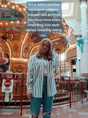 A woman stands in a mall setting in front of a carousel. She is wearing a striped shirt and jeans. Text overlay covers the top.