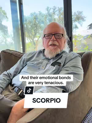 An older man with glasses and a white beard is seated on a brown couch in front of a large window. Text overlays state, "And their emotional bonds are very tenacious," and "SCORPIO." A social media logo is present.
