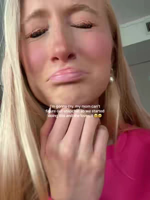 A close-up shot shows a blonde woman with fair skin, eyes closed, forming a slight pout with her lips. She appears to be crying, with visible redness and streaks on her cheeks. Added text overlay adds context.