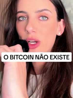A woman with long brown hair and blue eyes is holding a microphone, and there's a white rectangle with text that says: O BITCOIN NAO EXISTE.