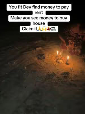 The cover image shows a dimly lit outdoor scene, likely at night. The foreground is dominated by a sandy or earthen surface. In the center, there is a collection of items around which three candles are lit and some form of hand or object is reaching, creating a central focus with warm light against the darker background. Text overlays are present at the top and bottom of the image.