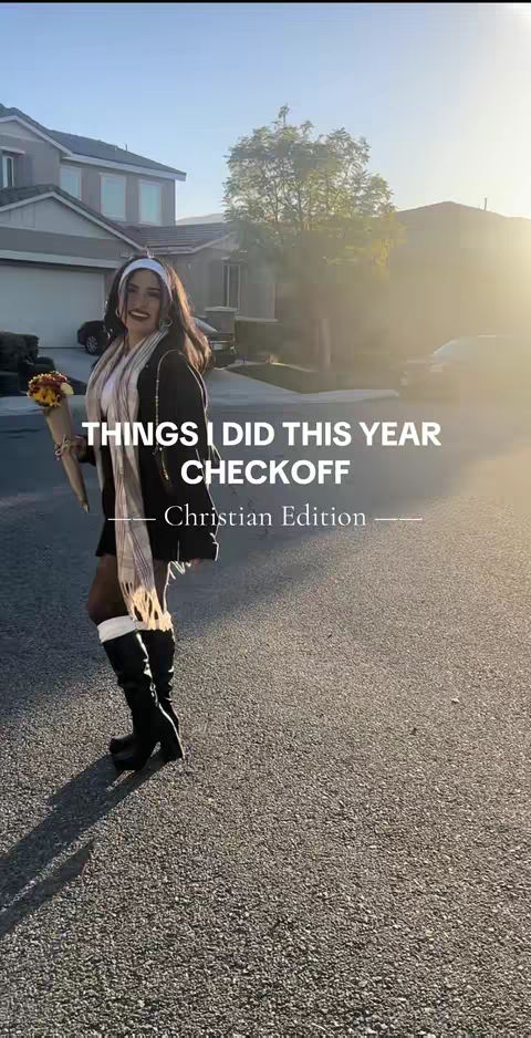 A woman stands on a driveway, holding a bouquet. She is dressed in a black blazer, white scarf, black miniskirt, and tall black boots. Text overlays state 'THINGS I DID THIS YEAR CHECKOFF Christian Edition.' The background includes suburban houses and sunlight.