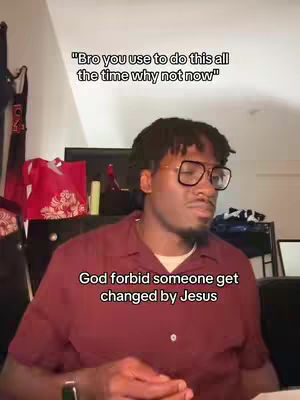 A man with glasses and a red shirt sits in a room. Text overlays are above and below him. In the background is a red tote bag.