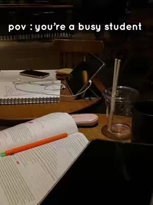 The cover image shows a table setting with study materials and a few tech items. An open book with an orange pen on it is in the foreground, with a smartphone, tablet propped up, and a notebook with headphones visible. The setting suggests a study location.