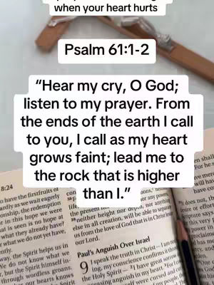 The cover image shows a slightly angled view of an open book with text from Psalm 61:1-2 highlighted in a white box. A wooden cross is placed on top of the book, and a pencil is resting on the page. The background has a neutral, soft aesthetic with focus on the lighting and the text's visibility. The colors are muted with warm tones.