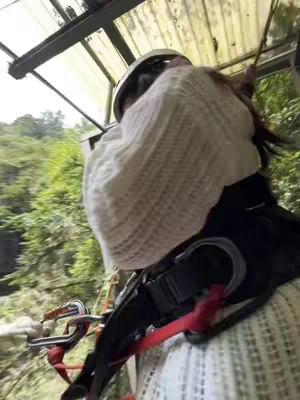 The cover image shows a first-person perspective of someone about to go on an adventure. The person is seen from the chest up, wearing a white sweater or top with a knitted pattern, along with a harness, helmet, and other safety equipment related to zip-lining. Green foliage can be seen in the background. The image is slightly tilted.