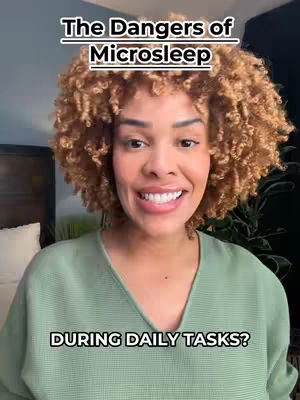 A medium shot shows a woman with curly brown hair smiling and looking toward the camera. The background includes a portion of a dark headboard and a green plant. Text overlays read "The Dangers of Microsleep" at the top and "DURING DAILY TASKS?" at the bottom.