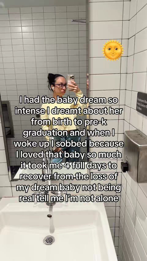A person is taking a mirror selfie in a bathroom. The person is wearing glasses and holding a phone. The bathroom has white tiles and a sink in the foreground. Text is overlaid on the image.