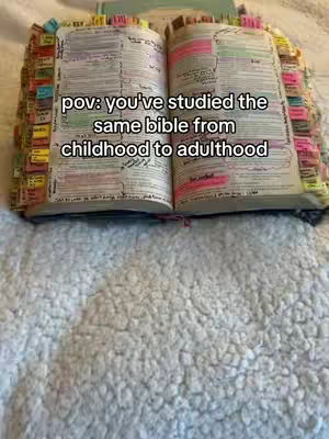 An open bible with many sticky notes, on a white bedspread. The text overlay is centered and reads 'pov: you've studied the same bible from childhood to adulthood'.