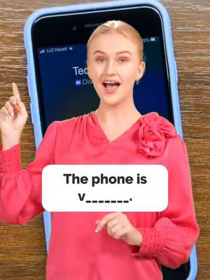 A woman is shown on a cover image. She is wearing a pink shirt and holding an iPhone. The background is a wooden table and a light-blue phone case. There is a white speech bubble which says 'The phone is V_______.'