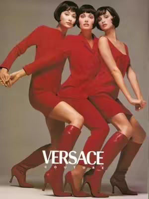 The cover image showcases three women in identical poses, suggestive of a fashion advertisement. They are wearing red outfits and boots. The Versace logo is prominently displayed.