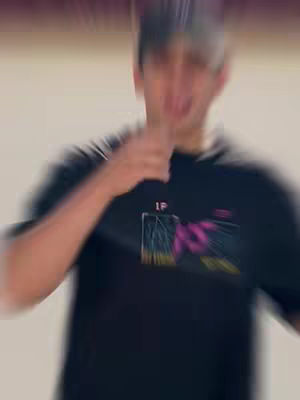 The cover image is slightly blurry, featuring a person of ambiguous ethnicity, wearing a black t-shirt with a colorful graphic design. The person is in the middle of an action, possibly gesturing with a hand near their mouth. The background is plain and light-colored. The overall composition is simple, focusing on the person.