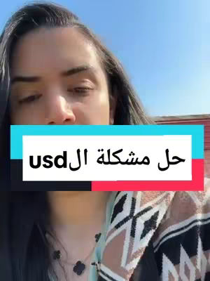 A woman with dark hair and a patterned top, framed from the chest up. Overlaid on her face is a horizontal rectangle with text in Arabic.