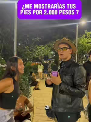 The cover image shows a man wearing a hat, glasses, and holding a microphone, appearing to interview two women in an outdoor setting at night. A text overlay reads, "¿ME MOSTRARIAS TUS PIES POR 2.000 PESOS ?". The scene is illuminated by streetlights and the overall tone suggests a candid or street-style interview.