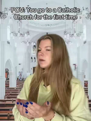 A woman with long brown hair is holding her hands up in front of her chest, as if in prayer. She is wearing a yellow hoodie and has blue nail polish. In the background is a church interior with rows of pews and arched windows filled with white light.