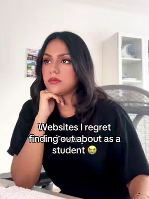 A medium shot shows a person with dark hair seated in a chair in front of a desk, with text overlayed on the image. The person is looking to their left with one hand in front of their face, appearing to be thinking or pondering. The background shows a room with white walls and a cabinet.