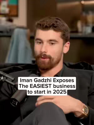 A close-up shot of a man with a beard and short, dark hair. He is wearing a black blazer and looking slightly off-camera. Overlay text indicates the video's topic.