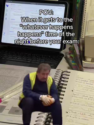 The image depicts a man in a hi-vis vest sitting on the floor, looking down and holding something. Behind him is a desk with a laptop and notebooks, and a screen overlay with text.