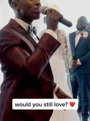 A man in a burgundy suit holds a microphone, centered in the frame. He's positioned in front of a woman in a white wedding dress, who is slightly out of focus. Another man in a blue suit is visible in the background. At the bottom is overlayed text: "would you still love? ❤️".