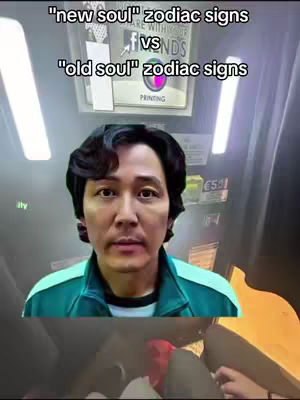 A man in a green jacket is centered in the frame against a blurry background. Above him, text reads "new soul" zodiac signs vs "old soul" zodiac signs. The background includes a partially visible sign and lights. Below the man, parts of a car seat appear.