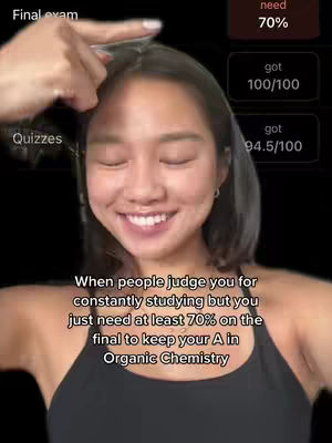 A selfie-style shot with a smiling young woman, framed from chest up against a dark background. A graphic panel on the right displays test scores: 100/100 and 94.5/100 from quizzes, and a 'need 70%' label for the final exam. The hand of the person is pointing toward her head.