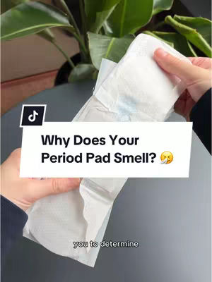 The cover image shows a close-up of a period pad held by a person's hands. The pad is white with some blue liquid stain. Below the pad, there is a black surface and a green leafy plant. The text overlay reads, "Why Does Your Period Pad Smell?" and a face with a steam coming out of the nose emoji.