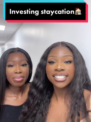 Two young African American women are centered in the shot. They are smiling and looking towards the camera. The woman on the right has long flowing wavy hair and the other one has straight long hair. The background is a light-colored wall.