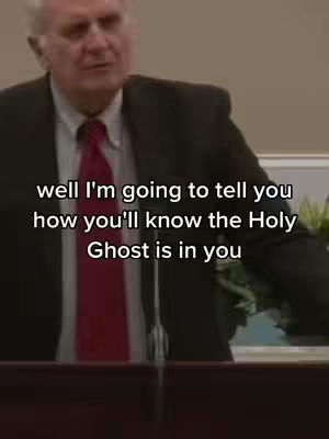 A man in a suit and tie is speaking, likely in front of a church congregation.