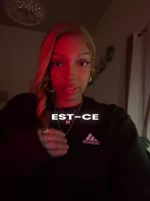 A woman with blonde hair and a dark top is looking at the camera, with text in a white box overlaid on her chest.