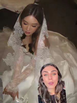 The cover image shows a woman in a wedding dress and veil, with a smaller inset of another woman speaking. The main figure is seated, possibly adjusting the dress. The inset image shows the creator, with makeup, looking directly at the camera.