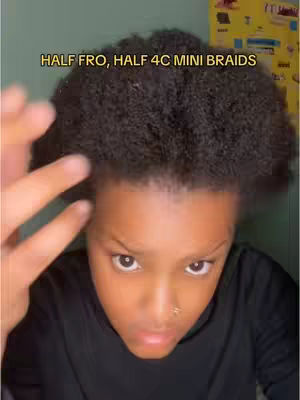 A person with dark, textured hair is centered in the frame, with a portion of their face visible. They have a nose piercing, and a top is visible.