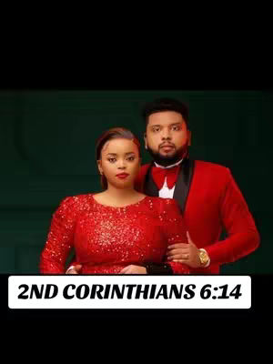 A couple in formal attire poses against a dark green backdrop. The woman wears a sparkling red dress, and the man is in a red suit with a black bow tie. A text overlay at the bottom reads '2ND CORINTHIANS 6:14' in a white rectangle.