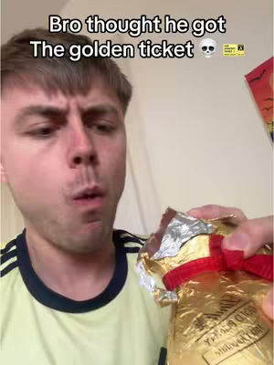 A man with short brown hair looks directly at the camera with a surprised or disappointed expression. His mouth is slightly open. He holds a golden Lindt chocolate in foil. Text overlayed at the top reads: "Bro thought he got The golden ticket".