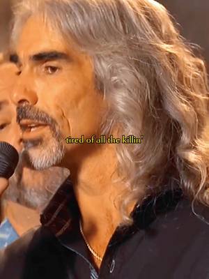 The cover image shows a close-up of a man with graying hair and a mustache, holding a microphone. Overlayed on the image is text at the bottom.