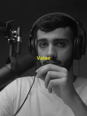 Black and white portrait of a man with a beard and short hair, wearing headphones and a white t-shirt. The word 'Value' is overlaid in yellow near his nose. A microphone is visible to his left.