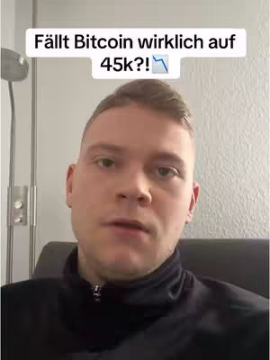 A man in a black jacket is centered in the frame, looking towards the camera. Above him is a text overlay in a white rectangle that says 'Fällt Bitcoin wirklich auf 45k?!' with a downward trending arrow symbol. The background is a light-colored wall.