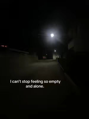A nighttime landscape shot with a dark alleyway leading into the distance, a bright light is overhead, and text overlays at the bottom.