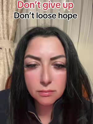 A woman with dark hair looks down with a neutral expression in front of a neutral background, with overlaid bold script text that reads: "Don't give up Don't loose hope".