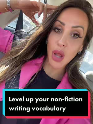 A woman with long, wavy brown hair and makeup is looking directly at the camera with an open mouth. She is wearing a pink blazer over a black top. The background is blurred, suggesting a car interior. A text overlay at the bottom states, Level up your non-fiction writing vocabulary.