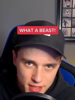 A close-up shot features a young man in a black cap and hoodie, looking towards the camera. A red rectangular overlay with white text that reads "WHAT A BEAST!" is positioned above his head. The background suggests a gaming or streaming setup with a chair, accessories, and framed artwork.