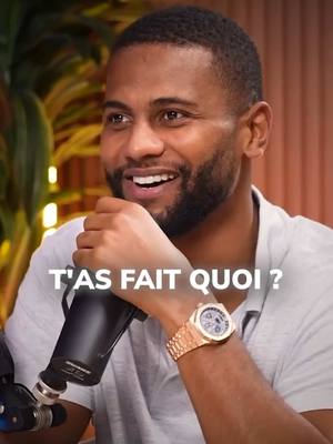 A close-up shot of a smiling Black man holding a microphone. The background is blurred, likely an indoor setting. Overlayed text reads 'T'AS FAIT QUOI ?', indicating a question or inquiry.