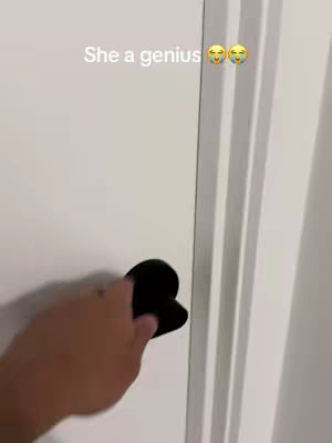 The video shows a hand opening a white door with a black heart-shaped door handle. Above the door is the text 'She a genius' with two emojis.